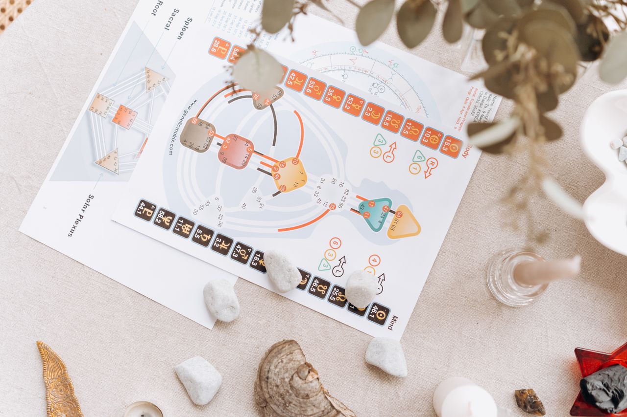 A serene setup of spiritual diagrams and crystals on a beige surface, symbolizing holistic healing and balance.